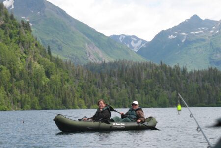 two people with fishing gear in a canoe on a lake in Alaska